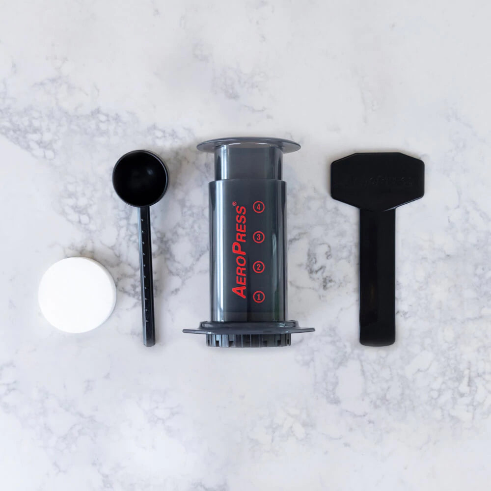 Aeropress coffee maker, stirrer and paddle and papers. A camp coffee equipment main stay, for coffee on the go. Use fresh ground coffee for best results. Enjoy coffee at camp, next to the fire.