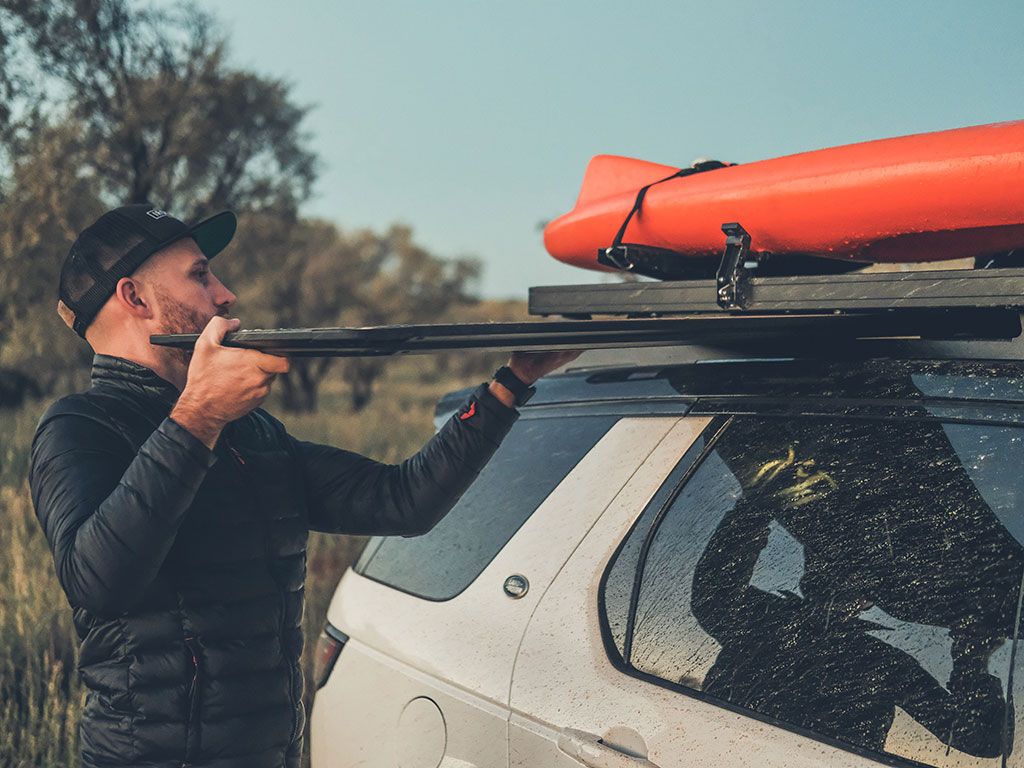 in use with man and kayak shot of front runner pro camp and prep table kit australia melbourne stainless camp table, the best and sturdiest and strongest, store under a roof rack slide it out the way